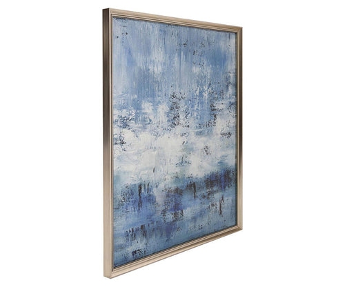 Abstract Sea Wall Art in Blue/Multi features a framed giclée print with textured blue and white brushstrokes inspired by coastal textures, creating a dynamic sense of movement and depth. The artwork is presented in a metallic or light-colored wood frame.