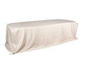 A long, rectangular table covered with a loose, light-colored Amar Dining Table Cover, designed to be water-resistant and suitable for all seasons.