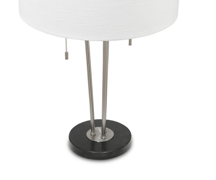 The Anderson Table Lamp showcases a contemporary design with a round white linen drum shade, three stylish metal rods forming the base, a circular black foundation, and an easy-to-use pull chain switch.
