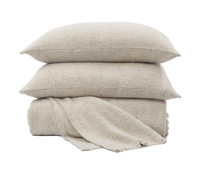 Two Andrea Pillows in Ivory A04 are stacked on top of a folded blanket made from the same fabric, all set against a white background—an ideal addition to your bedroom decor.