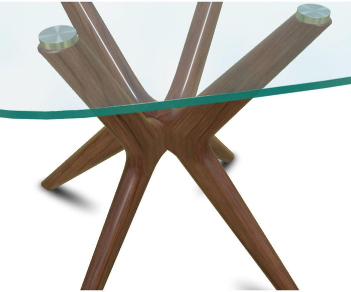 Close-up of the Ardal End Table, showcasing its modern glass top with a clear surface. The base consists of four angled European beech wood legs that intersect at the center, each finished with a metallic accent where it meets the glass.