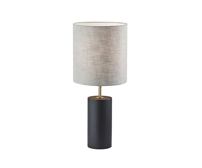 A modern table lamp featuring a cylindrical base in black and brass, topped with a tall, light gray fabric lampshade. With its minimalist and contemporary design, the Ash Table Lamp is an ideal choice for those seeking a modern rustic lamp style.