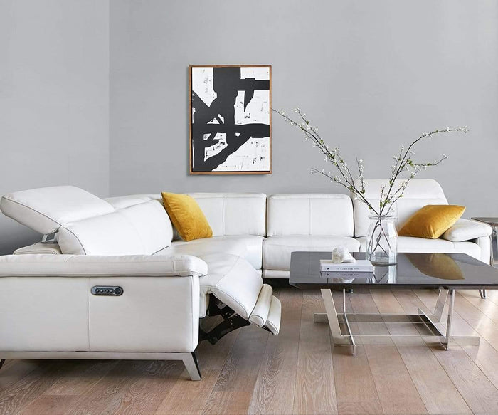 Modern living room with a white sectional sofa, two yellow pillows, a reclining seat, and glass coffee tables features a minimalist black-and-white abstract painting—accented by elegant brushstroke canvas art. A vase with branches rests on the light wood flooring, while the space’s refined decor is completed by the impressive Balkon Abstract Graphic Wall Art displayed above the sofa.