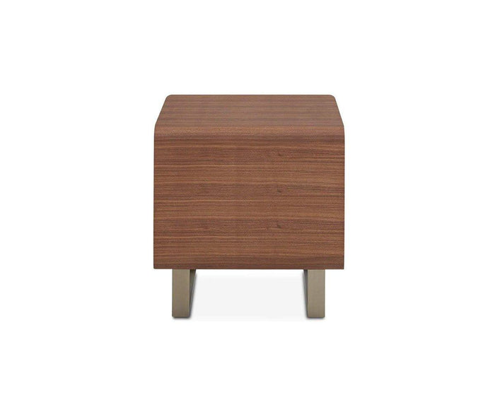 The Baptisia End Table is a compact, rectangular wooden side table with a refined cherry finish and sturdy metal legs. Displayed from the front against a white background, it showcases clean lines inspired by cubist art, seamlessly combining modern elegance with artistic sophistication.