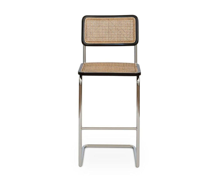 The Bendt Bar Stool in BENDT NATURAL/BLACK features a mid-century design with a chrome frame, rattan seat and backrest, and black trim, shown from the front against a white background.