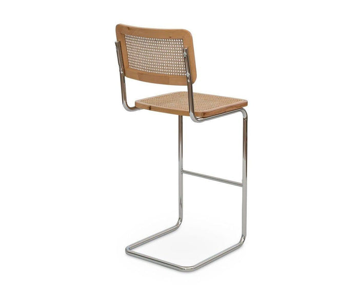 Introducing the Bendt Bar Stool: a cantilever chair featuring a chrome metal frame, seat and backrest crafted from light European beech wood, and a woven cane panel accenting the backrest. Shown against a white background, this stylish piece captures the timeless elegance of mid-century bar stool design.