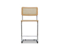 Introducing the Bendt Counter Stool in Bendt Natural—a modern, minimalist counter stool featuring a light wood cane seat and backrest, supported by a sleek metal frame. This mid-century inspired design showcases clean straight lines and a natural finish for an elevated yet timeless look.
