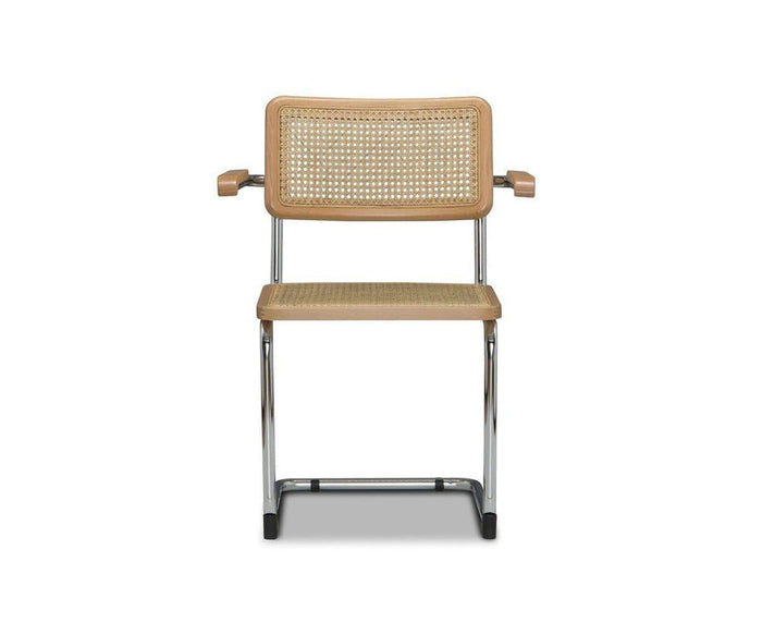 The Bendt Dining Armchair in BENDT NATURAL features a modern cane seat and backrest, complemented by a light wooden frame, chrome legs, and short beech wood armrests. It is shown against a plain white background.