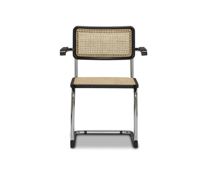 A front view of the Bendt Dining Armchair in BENDT NATURAL/BLACK, featuring a modern mid-century design with a chrome frame, black armrests, and woven cane seat and backrest, set against a plain white background.