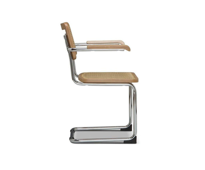 A side view of the Bendt Dining Armchair, featuring a modern chrome cantilever frame, wooden armrests, and a woven cane seat and backrest, set against a plain white background.