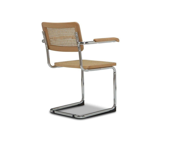 The Bendt Dining Armchair, featuring a cantilever chrome frame, light wood seat and backrest, and woven cane detailing, is shown from a rear three-quarter angle against a white background.