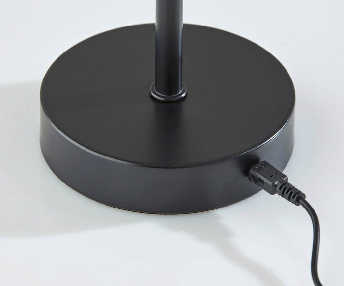 A contemporary design, the Benji Cordless LED Table Lamp features a black circular base with a central vertical pole. Its minimalist silhouette sits stylishly on a white surface, making it ideal for modern interiors.