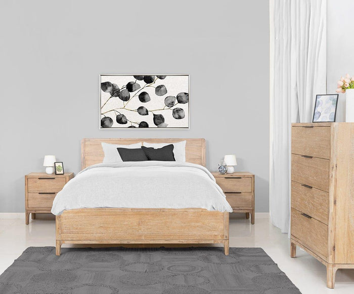 Minimalist bedroom with light wood furniture, grey rug, white bedding, and the Camen Nightstand beside the bed topped with a lamp. A dresser and botanical wall art above the bed add stylish touches, while white walls and curtains complete the look.