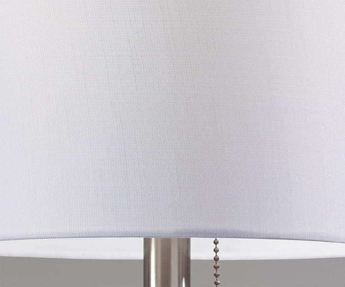 Close-up of the Cara Floor Lamp featuring a white fabric lampshade, a sleek metal base, and a pull chain visible on the right side, highlighting its elegant design.