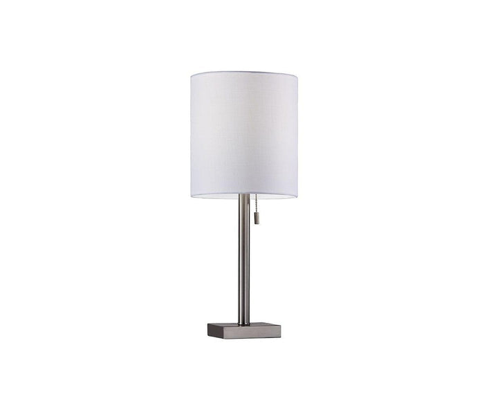 The Cara Table Lamp features a cylindrical white fabric shade, a slim metal base, and a pull chain switch, beautifully set against a plain white background.