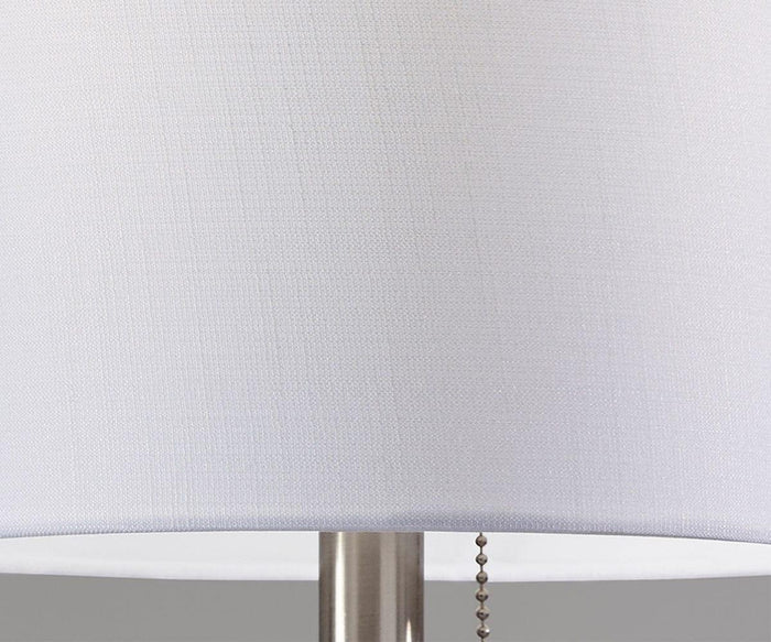Close-up of the Cara Table Lamp, which features a white fabric shade, a sleek metal base, and a pull chain hanging down the right side.