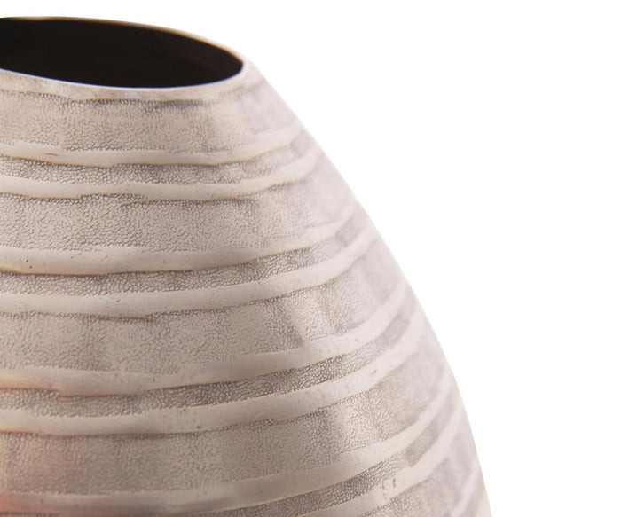 Close-up of the Chisled Champagne Small Vase, showcasing its textured, horizontally striped pattern. This modern metal vase features a matte champagne finish that enhances its elegant European style. The subtly reflective surface stands out against a plain white background, creating a minimalist aesthetic.
