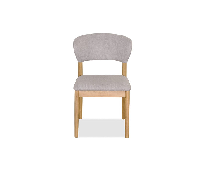 A front view of the Courbe Dining Chair in Natural, Scandi-inspired with a light-colored upholstered seat and backrest. Crafted from sustainable rubberwood, its simple and modern design features four straight legs and a gently curved back for comfortable support.
