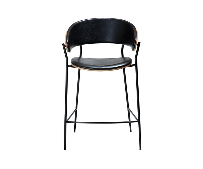 The Crib Leather Counter Stool in Vintage Black features a curved backrest, slim metal legs, and a cushioned seat that channels mid-century modern elegance, displayed against a plain white background.