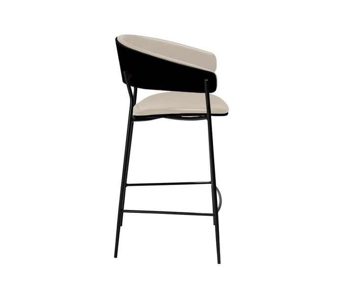 The Crib Leather Counter Stool features a contemporary design with a black metal frame, a light beige cushioned leather seat, and a matching backrest, shown in a side view against a plain white background.