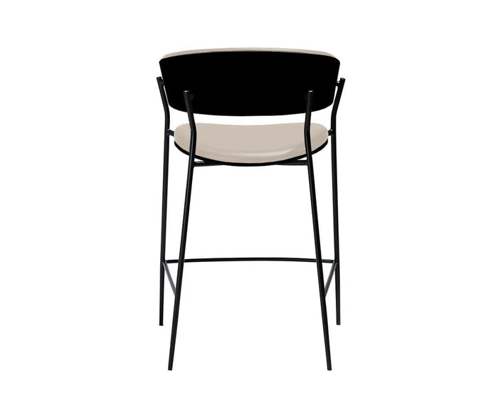 The Crib Leather Counter Stool features a contemporary design with a black backrest, light beige leather seat, and slender black metal legs. Shown from the back against a white background, this modern stool embodies mid-century sophistication, making it an elegant addition to any space.