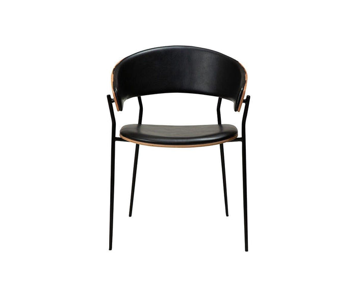 A contemporary Crib Leather Dining Chair in vintage black, featuring a curved backrest with a wooden accent along the edge and slender metal legs, is displayed against a plain white background. This modern dining chair seamlessly combines sleek design with subtle mid-century influences, making it a stylish addition to any space.