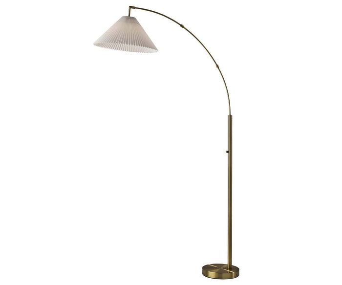 The Delaney Arc Lamp features a tall, arched brass stem and a pleated white conical lampshade, standing on a round base against a plain white background—a true statement piece for any living space.