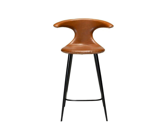 The Drake Counter Stool, shown in brown faux leather upholstery with a curved, wing-like backrest and black metal legs against a white background, combines rustic industrial charm and contemporary style to elevate any space.