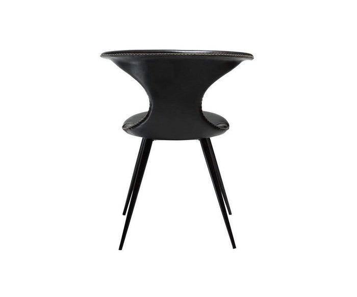 Introducing the Drake Dining Chair—a modern Danish-inspired piece in sleek black, featuring a rounded backrest and slim, curved seat upholstered in luxurious faux leather. Its rustic industrial style is accentuated by four thin, tapered black metal legs and is showcased from the back against a white background.