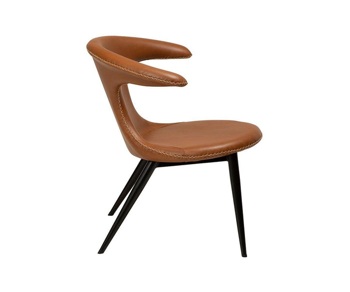 The Drake Lounge Chair features tan faux leather upholstery, a distinctive curved backrest, white stitching accents, and black tapered legs that highlight its rustic industrial style. The chair is displayed in a side profile view against a white background.