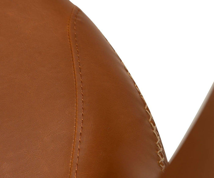 Detailed close-up of the Drake Lounge Chair’s brown faux leather upholstery, featuring visible stitching and curved seams that highlight its rustic industrial design.