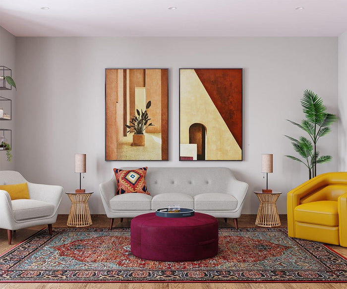 A modern living room with a gray sofa, yellow armchair, patterned rug, round ottoman with a walnut base, and side tables topped with the Dusk Table Lamp. Lush plants and two abstract art pieces adorn the walls. The space is bright and neatly arranged, capturing the essence of mid-century decor.