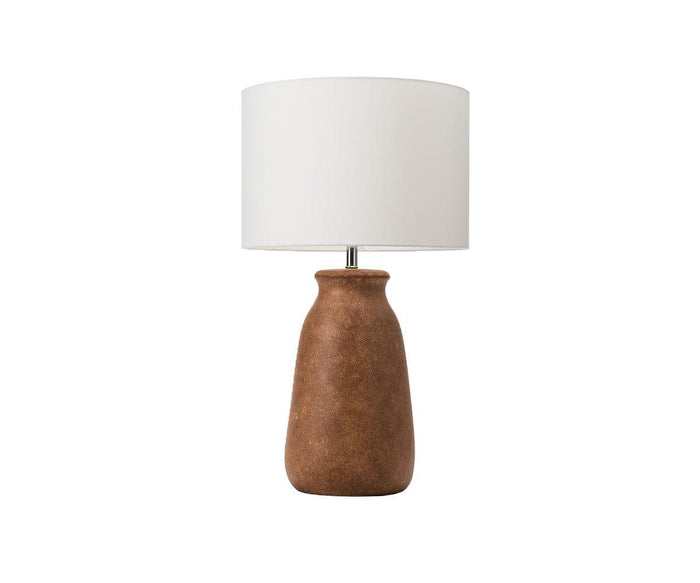 The Earthy Luster Lamp showcases a burnt amber terracotta base with a textured, matte finish and is paired with a large white cylindrical lampshade, set against a plain white background.