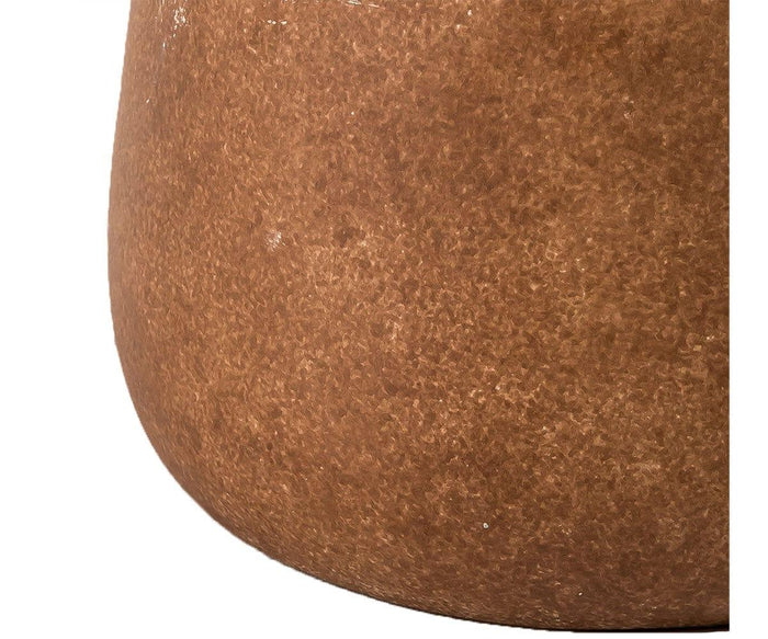 A close-up of the Earthy Luster Lamp’s textured brown ceramic surface, featuring a rounded shape and matte-finished base, set against a white background.