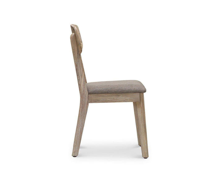 Side view of the Eckler Dining Chair, featuring a cushioned, upholstered seat and a simple, minimalist design. Crafted from solid acacia with a light, natural finish, the chair’s seat cushion is covered in neutral fabric.