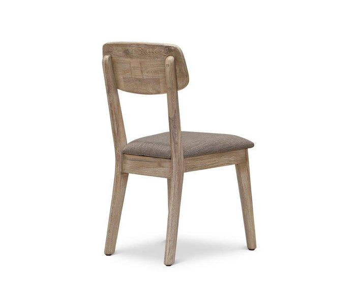 The Eckler Dining Chair is expertly crafted from solid acacia and features a light finish, a brown upholstered seat, and a curved backrest. Shown at an angle, it displays both the back and one side.