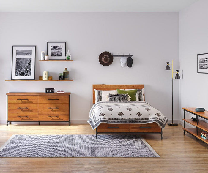 A modern bedroom with wooden furniture, neutral bedding, a gray rug, wall art, shelves, a hat on the wall, and an Eden 2-Light Floor Lamp on hardwood floors. The room has a minimalist, cozy style.