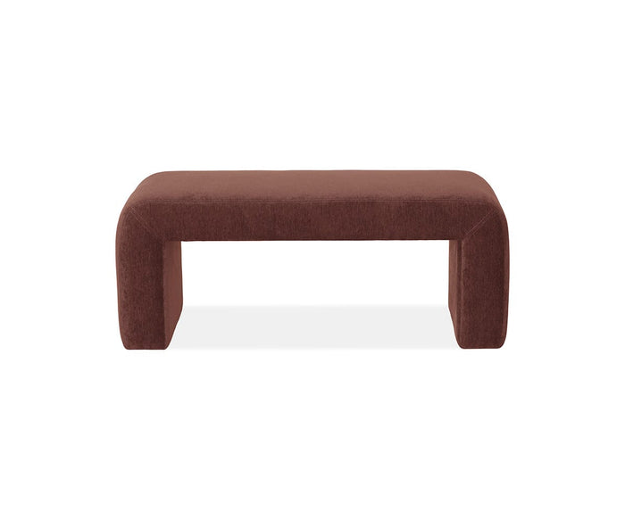The Eilir Full Bench features a F07 Rust-colored upholstered rectangular seat and legs that curve inward, creating a modern, minimalist silhouette. Ideal for extra seating, this full bench is showcased on a white background.