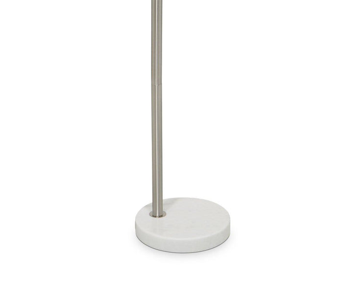 A close-up of the Elegans Floor Lamp’s slender stainless steel pole anchored in a circular white marble base, set against a plain white background and showcasing its signature arched frame.