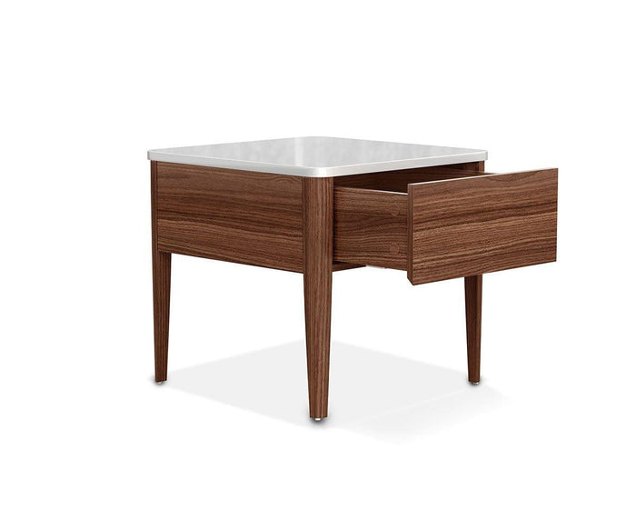 The Enna End Table showcases a modern design with a dual-toned finish, featuring a wooden base, tapered legs, a sleek white tabletop, and a single drawer that is slightly open.