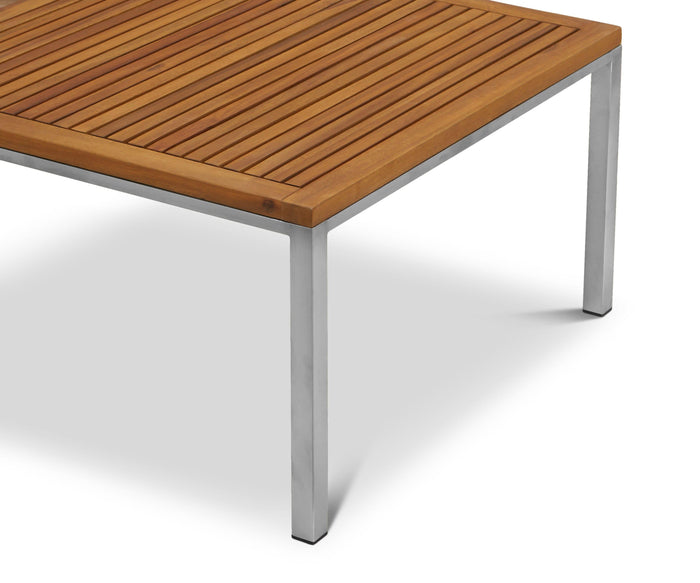 A close-up of the Farino Outdoor End Table highlights its solid acacia tabletop with wooden slats and sleek metal legs, photographed against a plain white background.