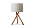 The Gaffel Table Lamp features a modern design with an acacia finish, a beige fabric drum shade, and three wooden legs forming a stylish tripod base—perfect for elevating your home decor. Shown against a plain white background.