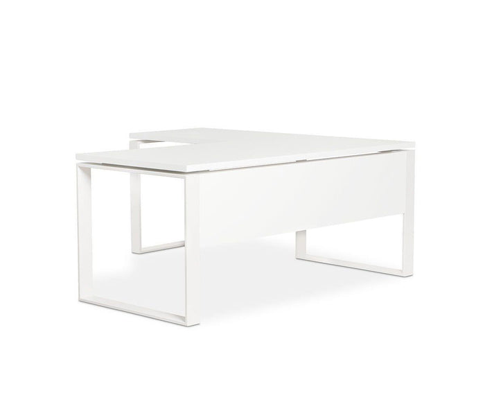 The Gammel Return Desk - White showcases a minimalist, modern aesthetic with clean lines, a flat rectangular surface, and open rectangular legs on either side. Crafted in Italy, this eco-friendly desk features a distinctive solid panel on the front and one side, as well as an integrated desk extension for added versatility.