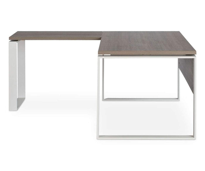The Gammel Return Desk is a modern L-shaped desk with a dark wood surface and white metal legs, displayed on a white background. This eco-friendly piece features clean, minimalist lines and an open, geometric frame design, proudly made in Italy.