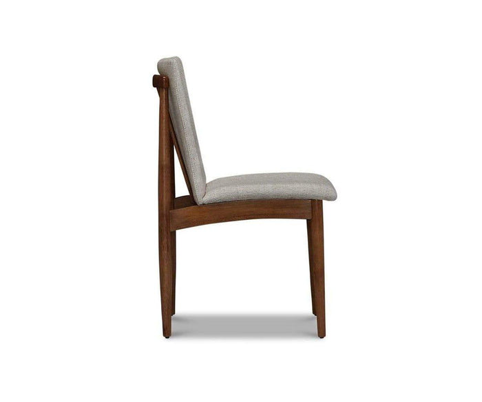 Side view of the Holfred Dining Chair, showcasing its modern wooden frame with a light gray upholstered seat and backrest. The chair highlights Scandi-inspired, mid-century modern design elements and is set against a plain white background.