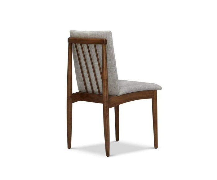 The Holfred Dining Chair exudes Scandi-inspired elegance with its light gray upholstered seat and backrest, shown angled from the rear. Vertical wooden slats and tapered legs highlight its refined mid-century modern design.