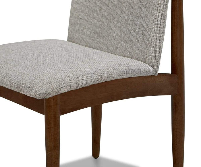 A close-up of the Holfred Dining Chair highlights its light gray textured upholstery on both the seat and backrest, complemented by clean lines and a simple, Scandinavian-inspired modern aesthetic.
