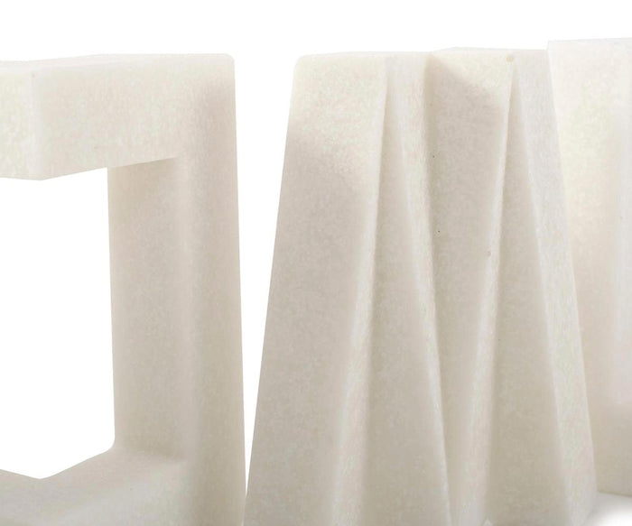 Close-up of the Home Sculpture, a white geometric piece with angled and folded surfaces, crafted to evoke modern decor, set against a plain white background.