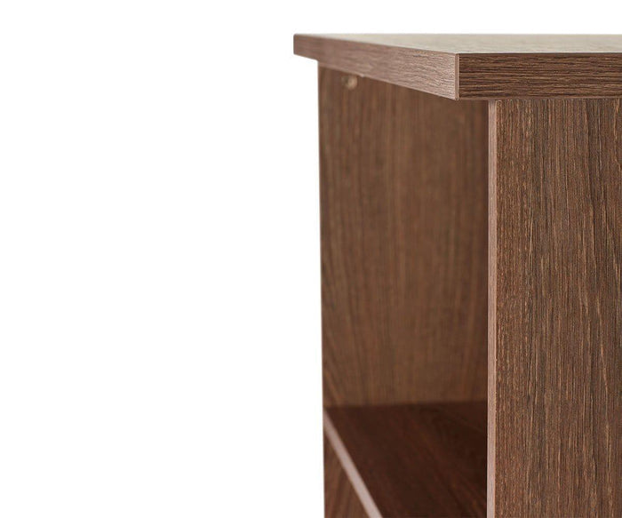 Close-up of the corner of the Inari Low Bookcase, highlighting the texture and grain of its brown wood and part of an adjustable shelf beneath the top surface.