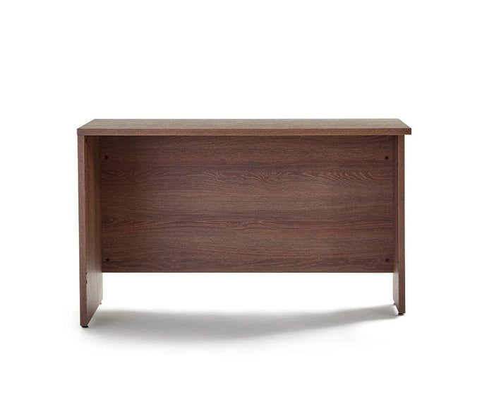 A simple wooden Inari Reversible Return with a dark brown finish, viewed from the back against a white background. Ideal for any office workspace, the desk features a flat top, solid side panels, and a back panel with visible wood grain.